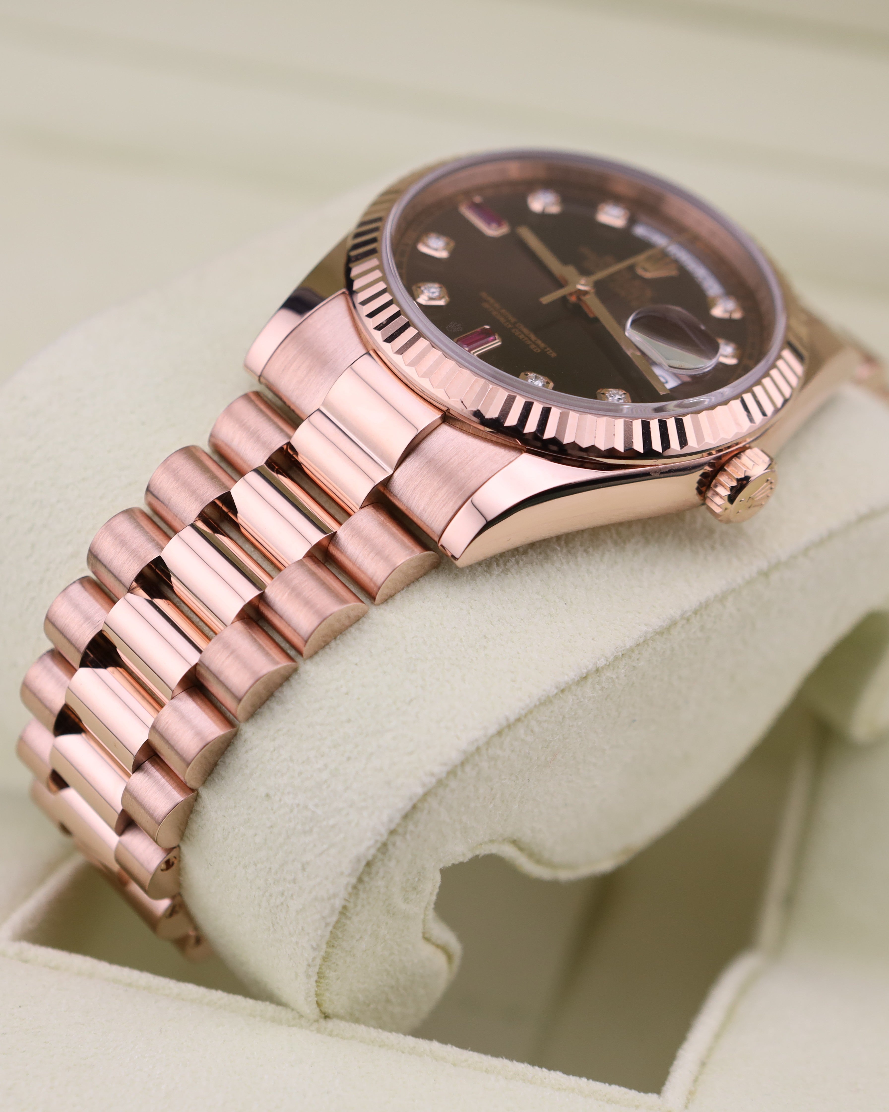 Rose gold watch on a white cushion