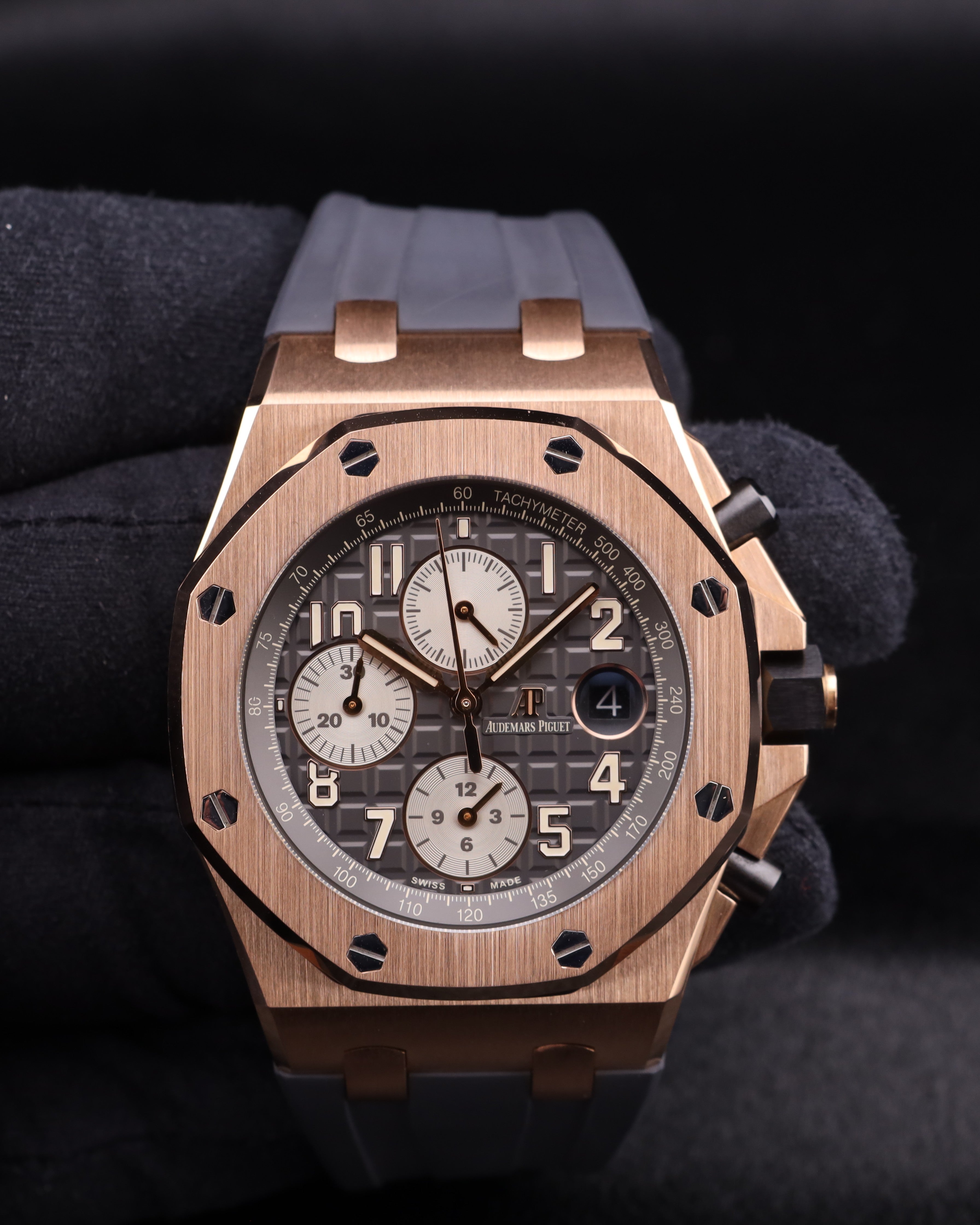 Luxury watch with rose gold case and detailed face on a dark background