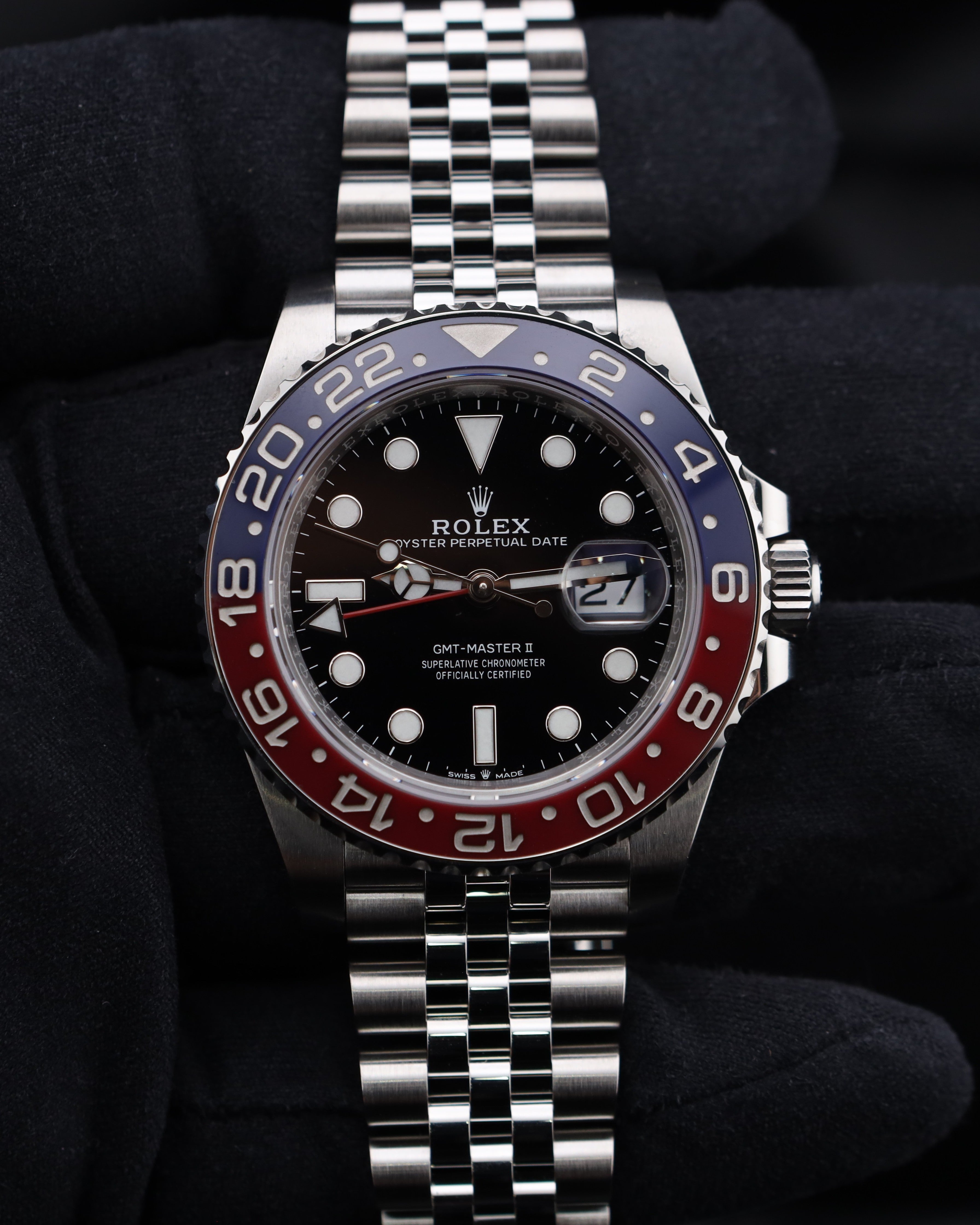 Rolex watch with a red and blue bezel on a dark background